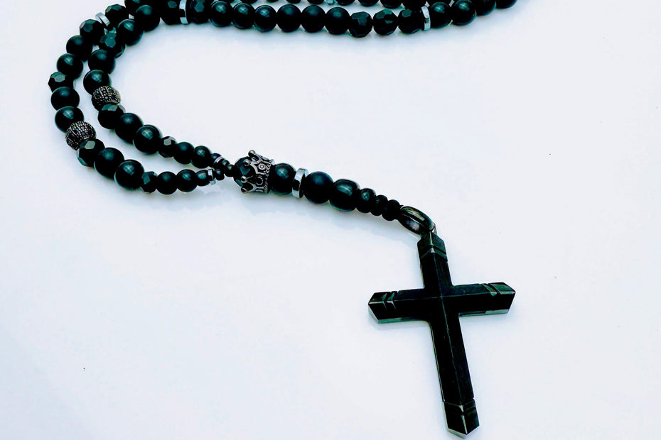 Schwarze Perlenkette aus Glas und Edelstahl mit stilvollem Kreuzanhänger – ein zeitloses Schmuckstück.
