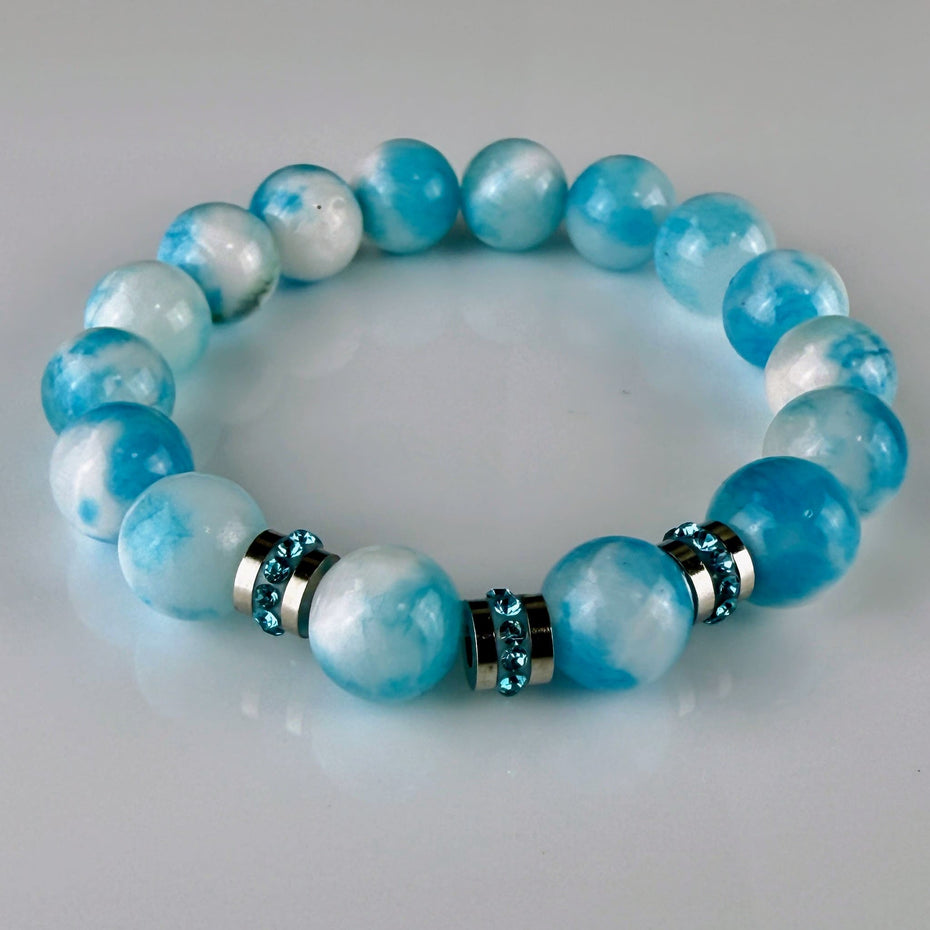 Handgefertigtes Armband aus blau-weißen Chalzedon-Perlen, ergänzt mit glänzenden Edelstahl-Elementen und funkelnden Strass-Kristallen – stilvoll und modern.