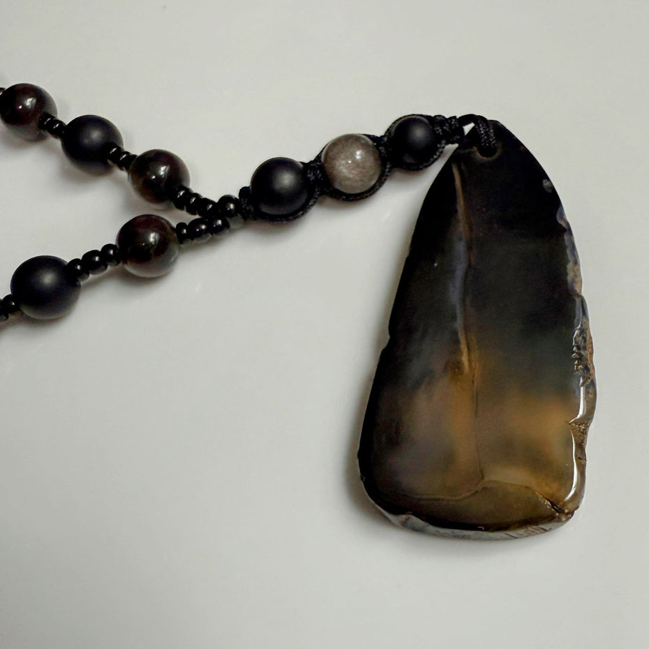 Handgefertigte Herren-Steinperlenkette mit matten Onyx-Perlen, schimmerndem Rauchquarz und einem großen geschliffenen Achat-Scheibenanhänger. Ein maskulines Accessoire, das Eleganz und Natürlichkeit verbindet.