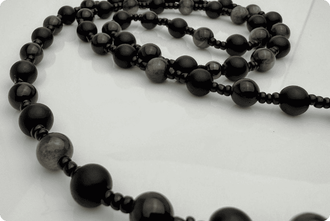 Handgefertigte Herren-Steinperlenkette mit matten Onyx-Perlen, schimmerndem Rauchquarz und einem großen geschliffenen Achat-Scheibenanhänger. Ein maskulines Accessoire, das Eleganz und Natürlichkeit verbindet.