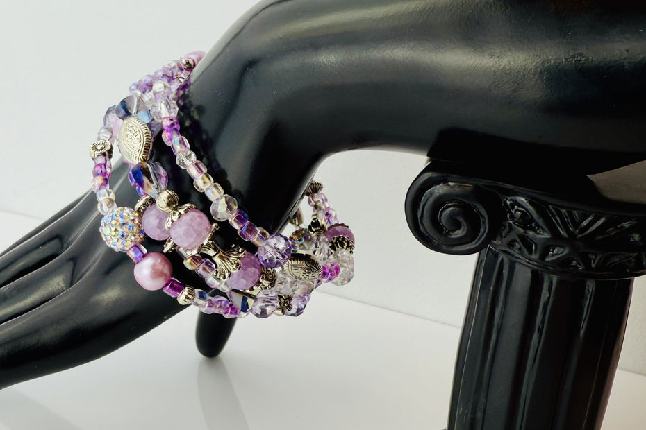 Handgefertigtes Spiralarmband in zarten Rosa- und Fliedertönen mit funkelnden Glasperlen, Strass-Elementen und filigranen Metall-Details. Flexibel und elegant, perfekt für besondere Anlässe und den Alltag.