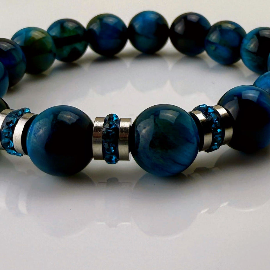 Blaugrünes Tigeraugen-Armband mit funkelnden Kristall-Edelstahl-Elementen, handgefertigt in der Schweiz. Vielseitiges und elegantes Design, das Strapazierfähigkeit und Stil vereint.