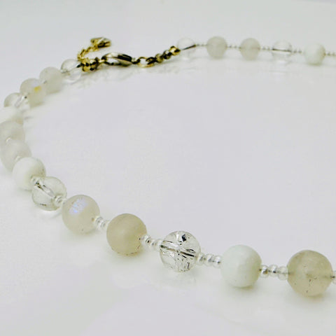 Zierliche Damenhalskette aus Mondstein- und Achatperlen, kombiniert mit transparent-weißen Rocailles. Handgefertigtes Schmuckstück aus der Schweiz, ideal für minimalistische und elegante Outfits.