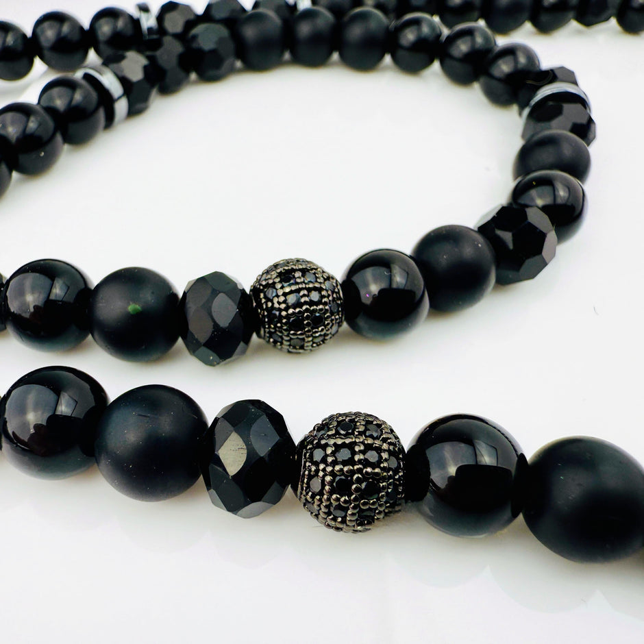 Hochwertige schwarze Perlenkette aus Glas und Edelstahl mit großem Kreuzanhänger aus Edelstahl, kunstvoll designt.
