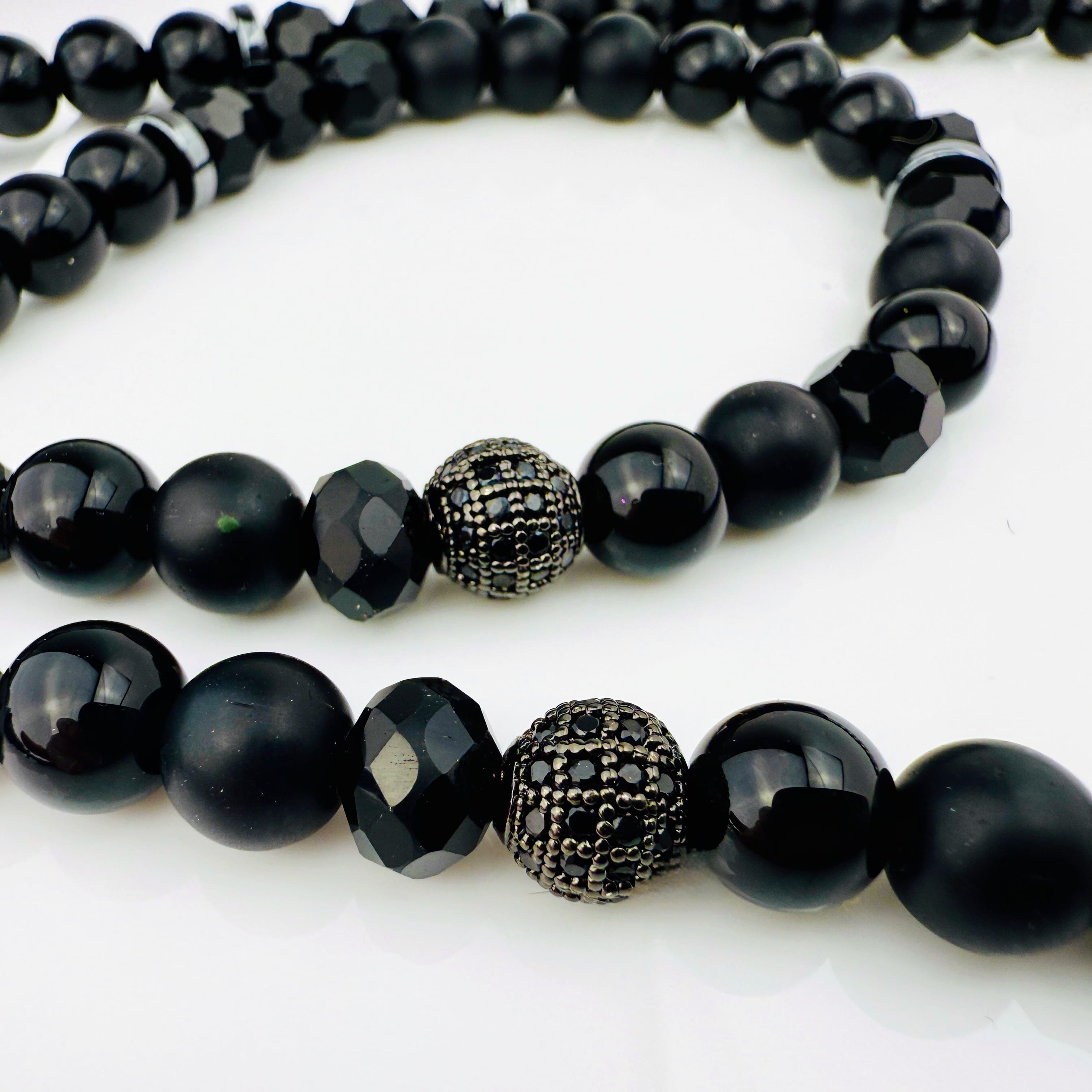 Hochwertige schwarze Perlenkette aus Glas und Edelstahl mit großem Kreuzanhänger aus Edelstahl, kunstvoll designt.