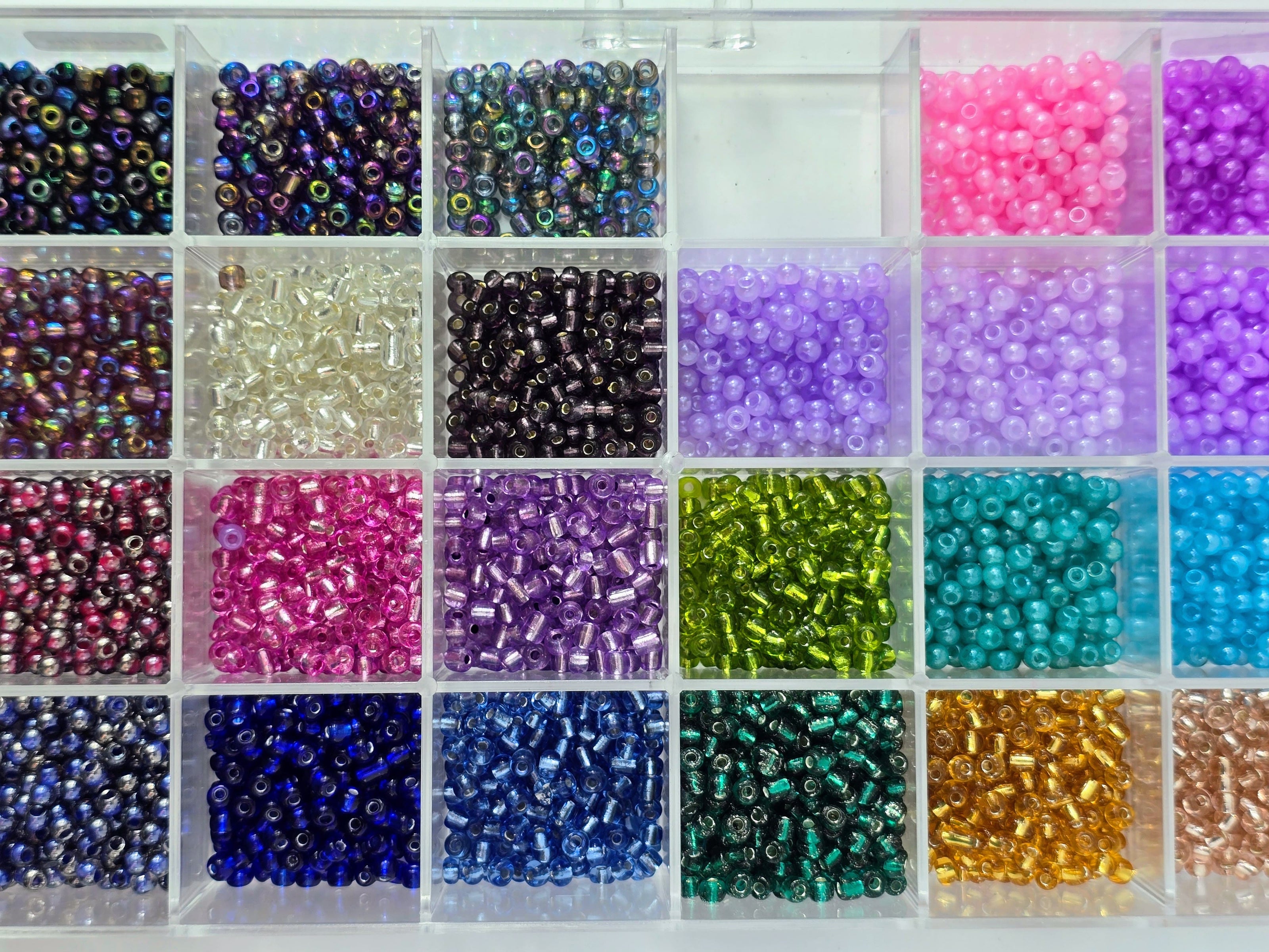 Kleine bunte Glasperlen (Roccailles), in 24 Fächerboxen hübsch dargestellt.