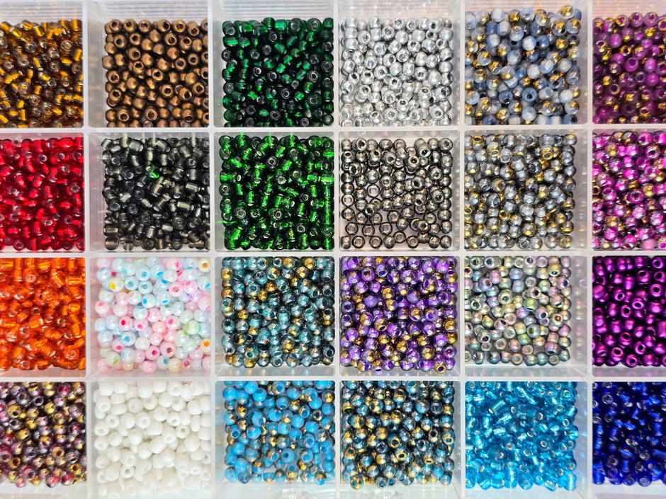Kleine bunte Glasperlen (Roccailles), in 24 Fächerboxen hübsch dargestellt.