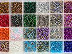Kleine bunte Glasperlen (Roccailles), in 24 Fächerboxen hübsch dargestellt.
