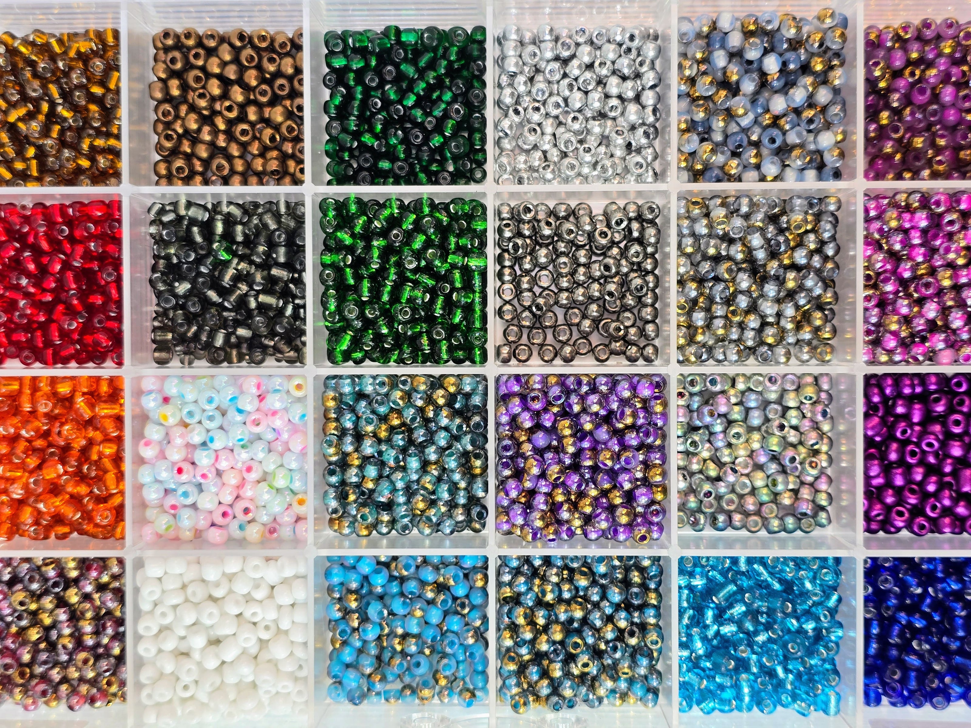 Kleine bunte Glasperlen (Roccailles), in 24 Fächerboxen hübsch dargestellt.