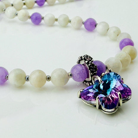 Perlenkette für Damen aus fliederfarbenem Achat und schimmerndem Mondstein, verziert mit einem detailreichen Schmetterling-Anhänger. Handgefertigt in der Schweiz, perfekt für romantische und feminine Styles.