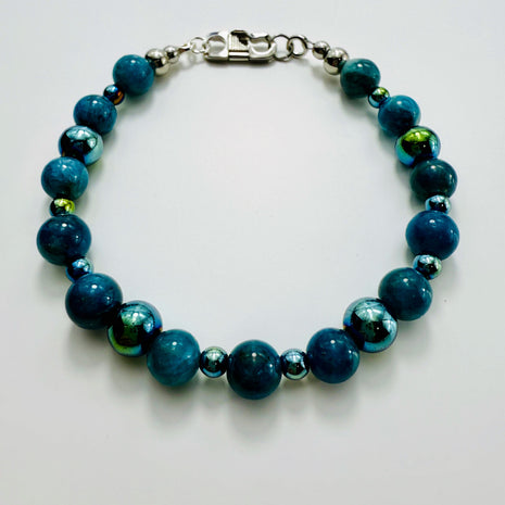 Armband aus blauen Apatit-Perlen und facettiertem Hämatit auf weissem Hintergrund, aufgefächert dargestellt.