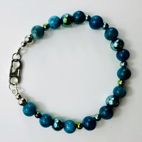 Armband mit Apatit- und Hämatitperlen in moderner Perspektive, auf hellem Untergrund.