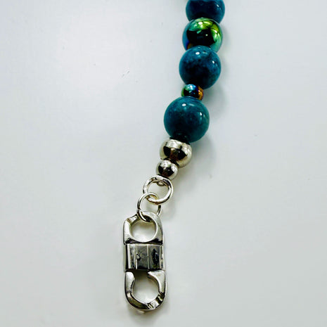 Armband mit Apatit- und Hämatitperlen in moderner Perspektive, auf hellem Untergrund.