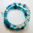 Blaues Armband aus Katzenaugen und funkelnden Glasperlen, handgefertigt auf Erinnerungsdraht.
