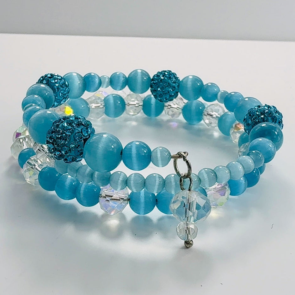 Blaues Armband aus Katzenaugen und funkelnden Glasperlen, handgefertigt auf Erinnerungsdraht.

