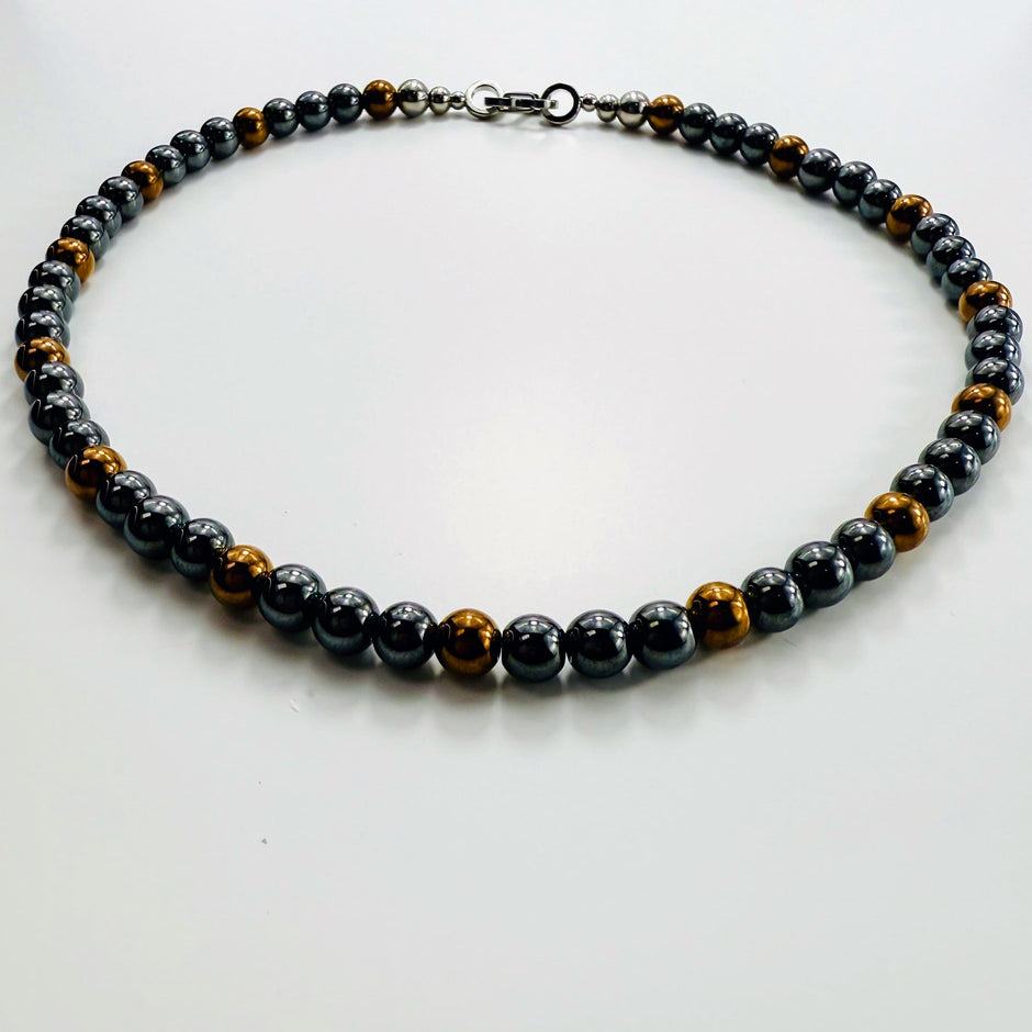 Runde Ansicht der Hämatit-Kette mit gleichmässigem Wechselspiel aus Schwarz und Goldbraun.