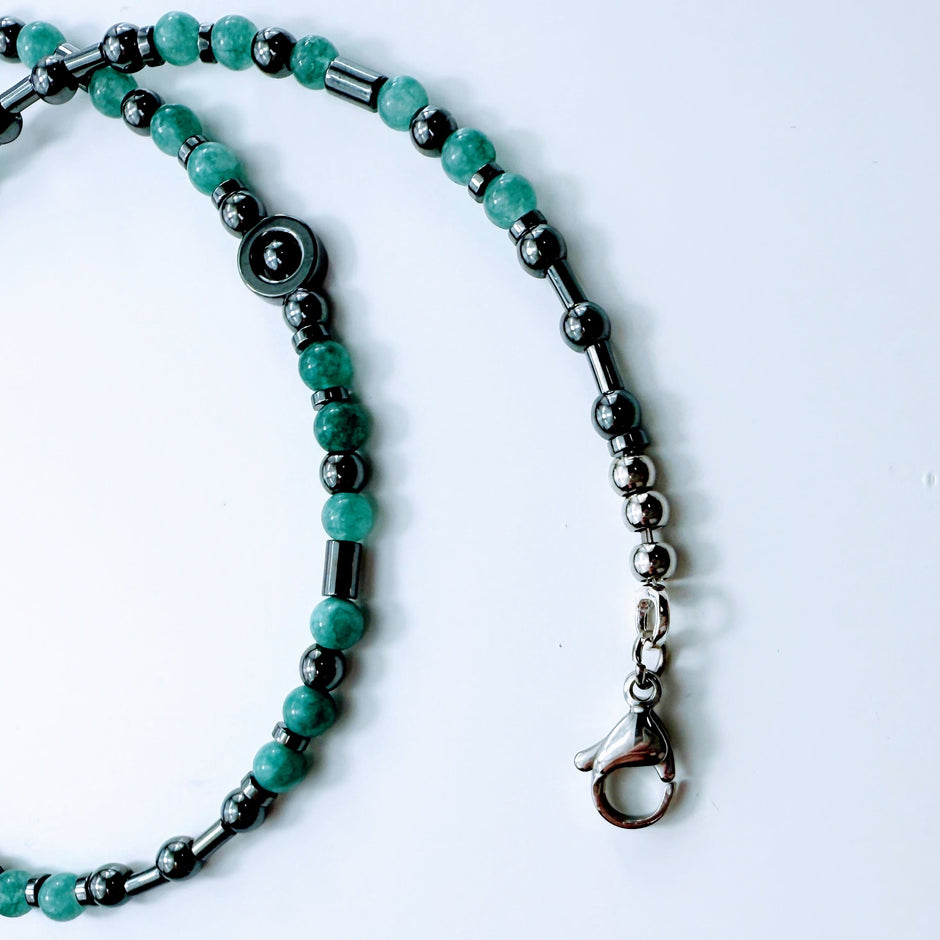 Die Kette in Kreisform gelegt – Kombination aus Edelstahlscheiben, Röhrchen und Aquamarinperlen.