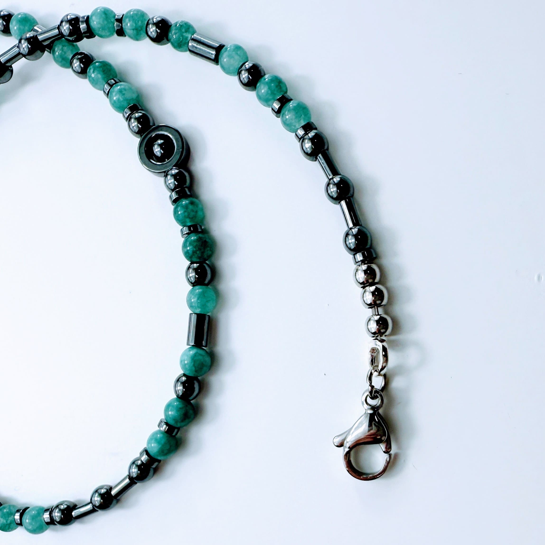 Die Kette in Kreisform gelegt – Kombination aus Edelstahlscheiben, Röhrchen und Aquamarinperlen.