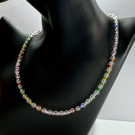 Zarte Regenbogen-Halskette aus Bergkristall auf schwarzem Schmuckständer stilvoll präsentiert