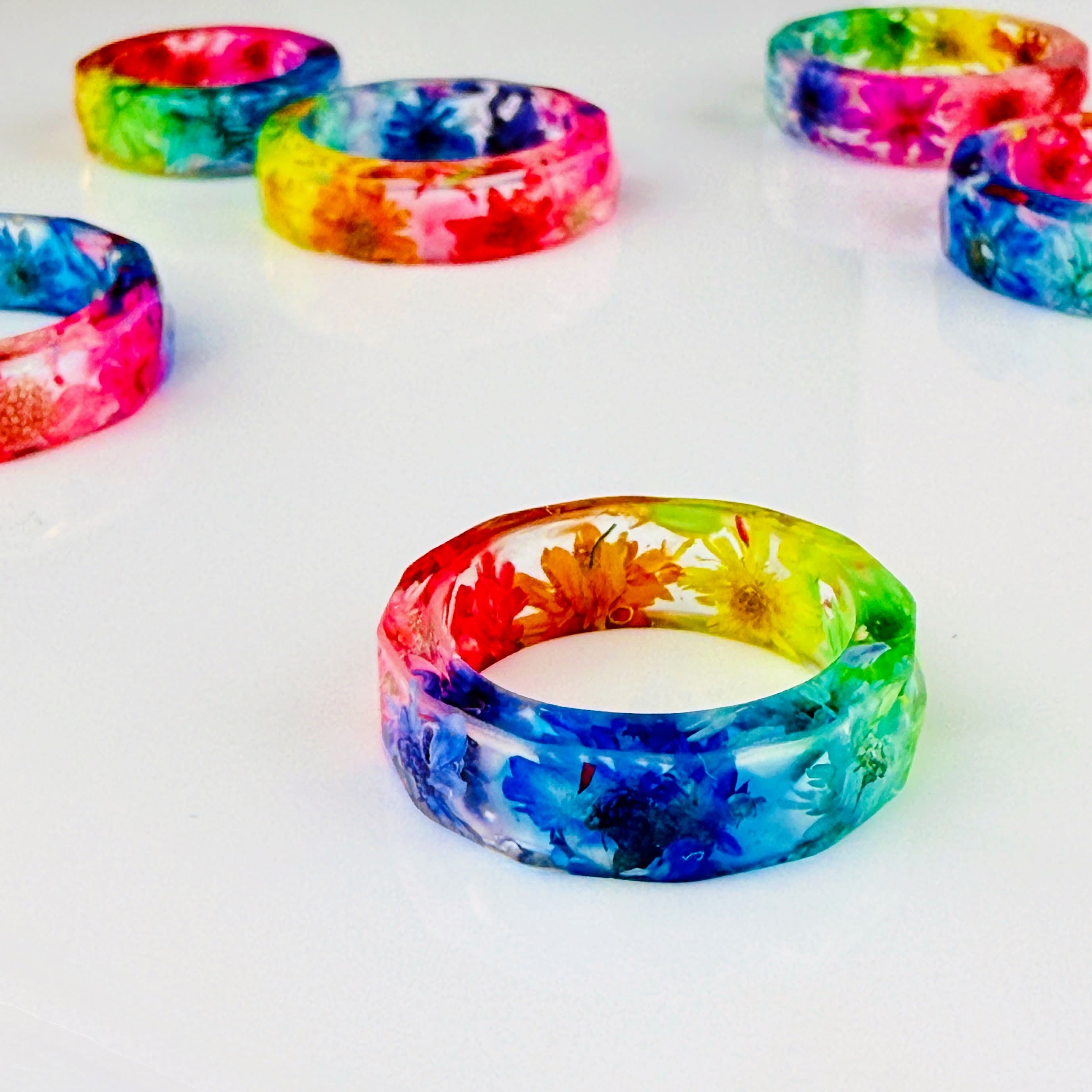 Handgefertigter bunter Seidenblüten-Ring aus klarem Epoxidharz von Elurea, in Schweizer Handarbeit gefertigt und individuell anpassbar im 'Style it yourself'-Konzept, aus hochwertigen Materialien.