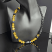 Herren Halskette mit Citrin- und Achat-Steinperlen, kombiniert mit schwarzer Edelstahlkette und asymmetrischem Design, handgefertigt in der Schweiz. Modern, langlebig und stilvoll – perfekt für lässige oder elegante Anlässe.