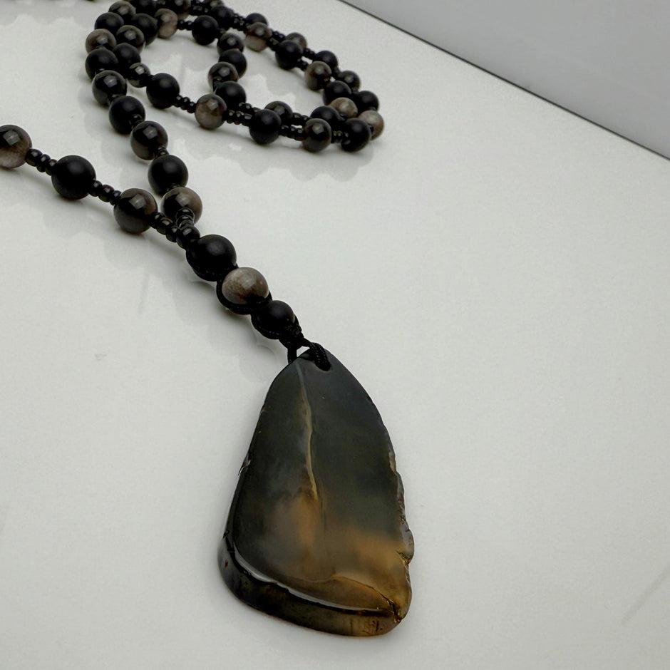 Handgefertigte Herren-Steinperlenkette mit matten Onyx-Perlen, schimmerndem Rauchquarz und einem großen geschliffenen Achat-Scheibenanhänger. Ein maskulines Accessoire, das Eleganz und Natürlichkeit verbindet.
