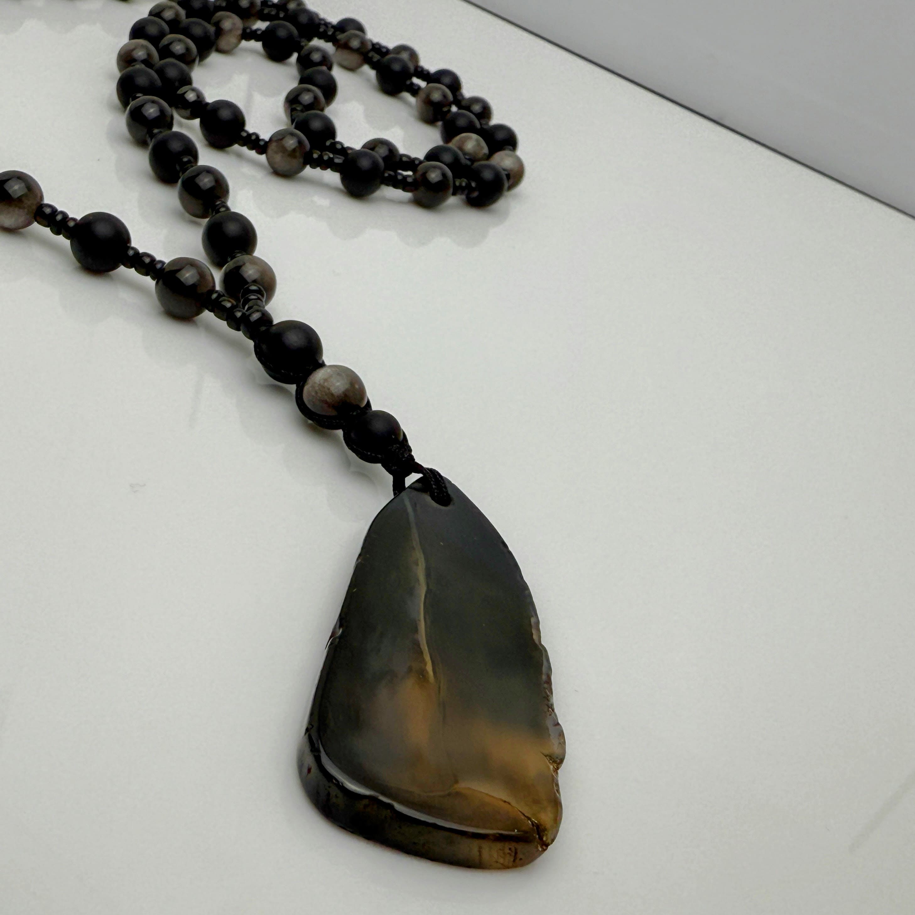 Handgefertigte Herren-Steinperlenkette mit matten Onyx-Perlen, schimmerndem Rauchquarz und einem großen geschliffenen Achat-Scheibenanhänger. Ein maskulines Accessoire, das Eleganz und Natürlichkeit verbindet.