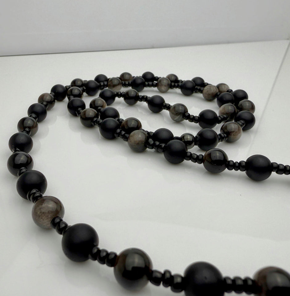 Handgefertigte Herren-Steinperlenkette mit matten Onyx-Perlen, schimmerndem Rauchquarz und einem großen geschliffenen Achat-Scheibenanhänger. Ein maskulines Accessoire, das Eleganz und Natürlichkeit verbindet.