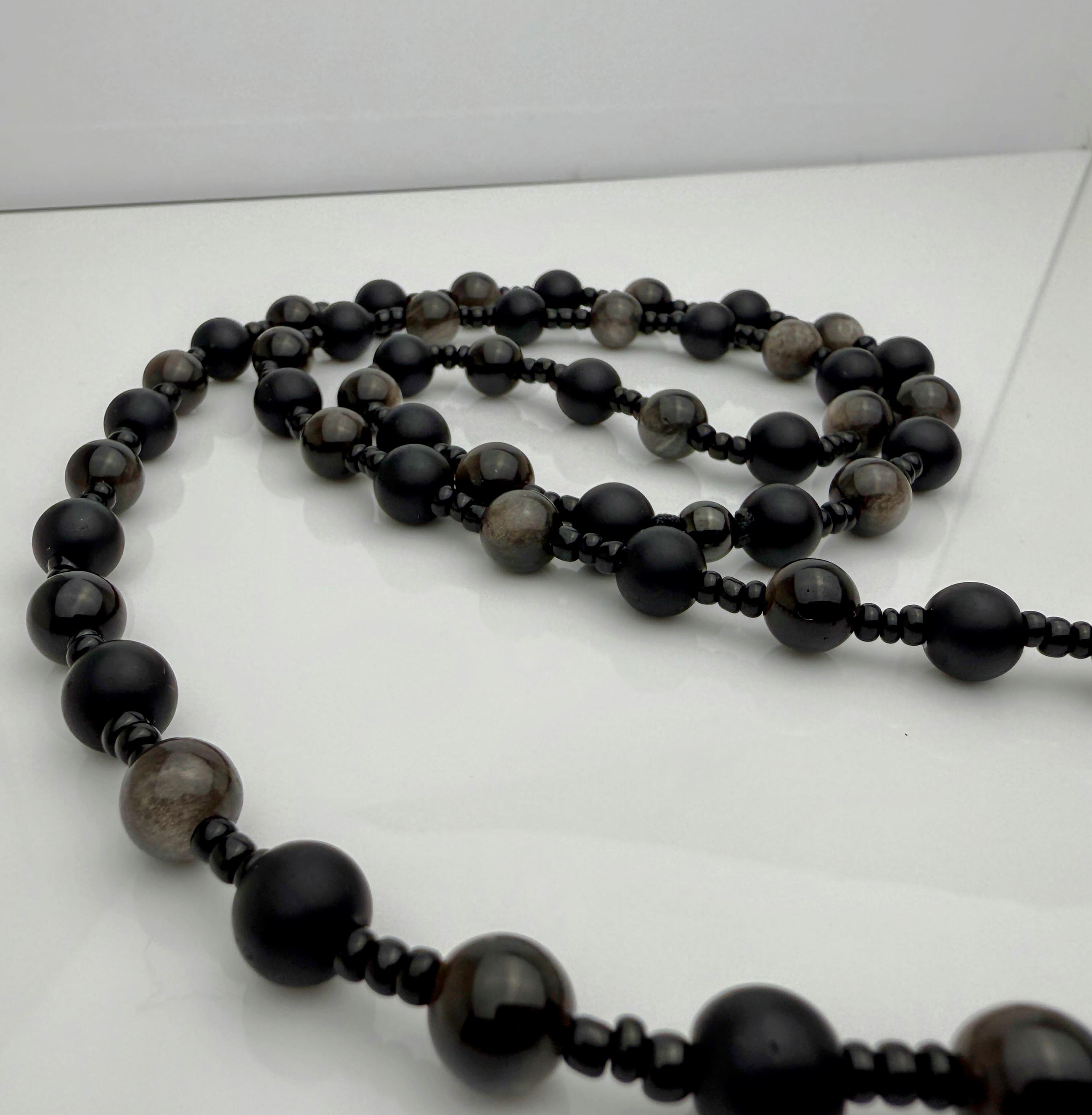 Handgefertigte Herren-Steinperlenkette mit matten Onyx-Perlen, schimmerndem Rauchquarz und einem großen geschliffenen Achat-Scheibenanhänger. Ein maskulines Accessoire, das Eleganz und Natürlichkeit verbindet.