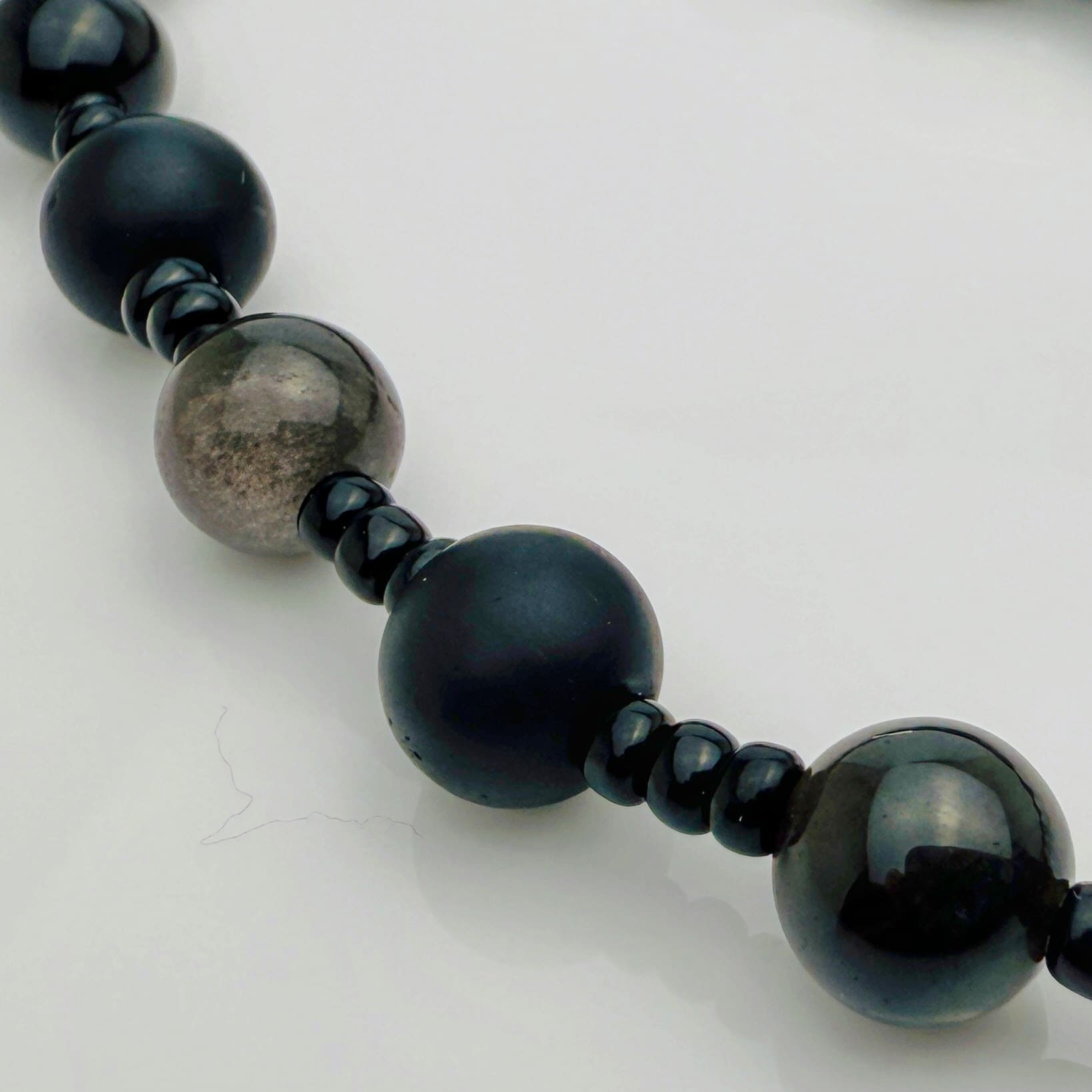 Handgefertigte Herren-Steinperlenkette mit matten Onyx-Perlen, schimmerndem Rauchquarz und einem großen geschliffenen Achat-Scheibenanhänger. Ein maskulines Accessoire, das Eleganz und Natürlichkeit verbindet.