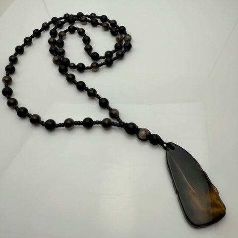 Handgefertigte Herren-Steinperlenkette mit matten Onyx-Perlen, schimmerndem Rauchquarz und einem großen geschliffenen Achat-Scheibenanhänger. Ein maskulines Accessoire, das Eleganz und Natürlichkeit verbindet.