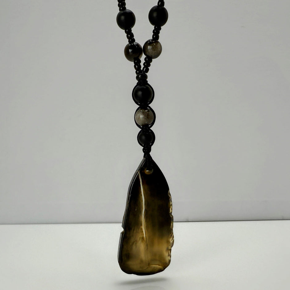 Handgefertigte Herren-Steinperlenkette mit matten Onyx-Perlen, schimmerndem Rauchquarz und einem großen geschliffenen Achat-Scheibenanhänger. Ein maskulines Accessoire, das Eleganz und Natürlichkeit verbindet.