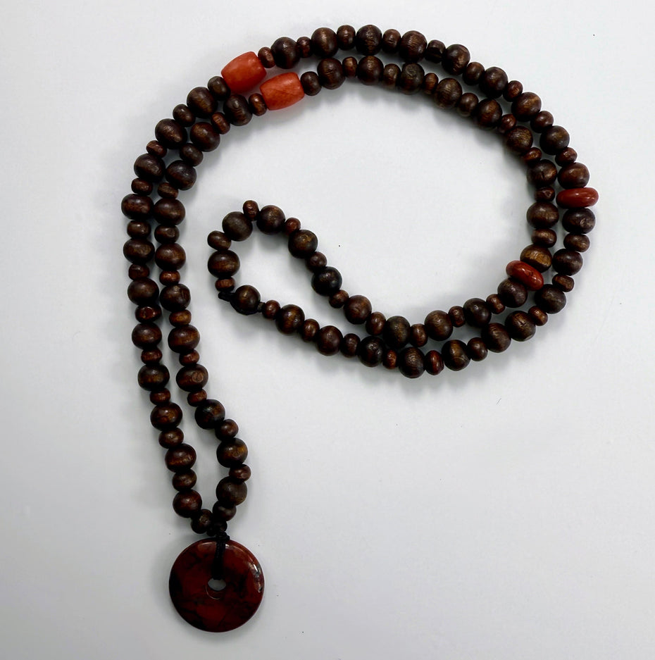 Karneol-Akzentperlen in warmem Orange zwischen dunklen Holzperlen