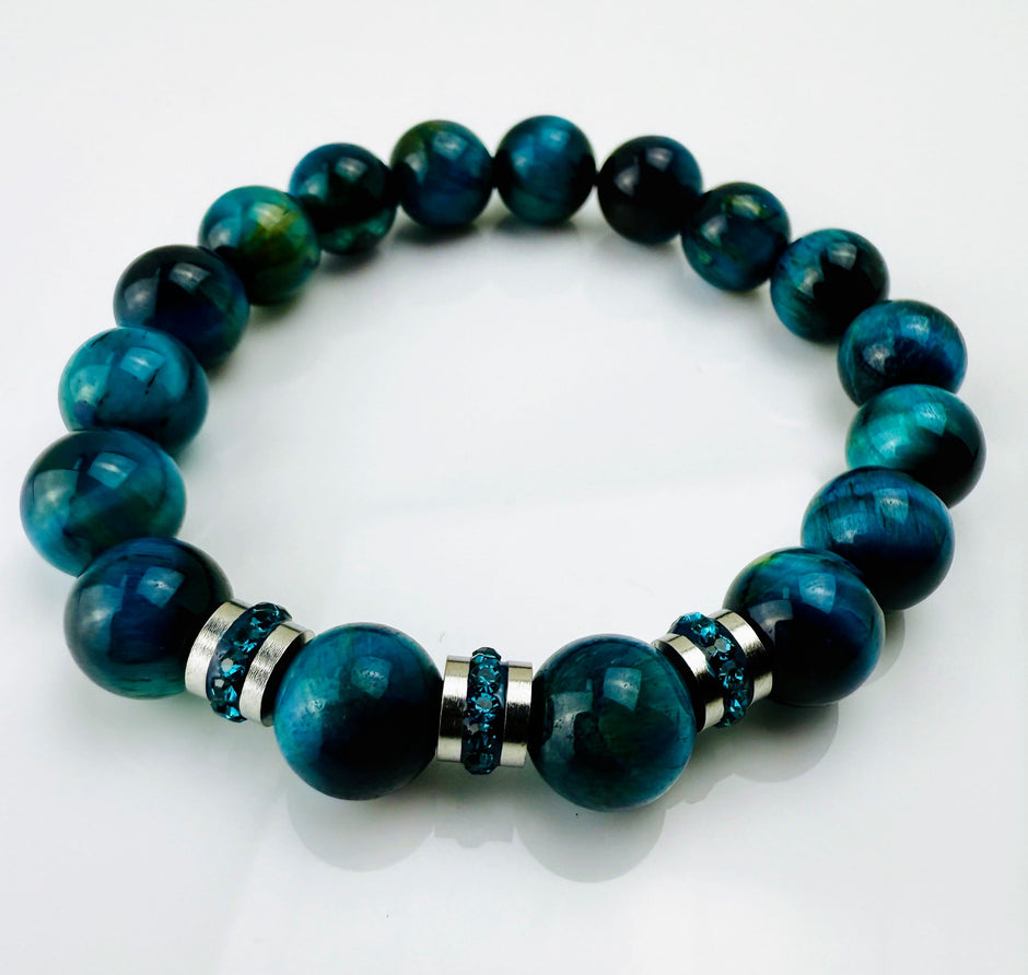 Blaugrünes Tigeraugen-Armband mit funkelnden Kristall-Edelstahl-Elementen, handgefertigt in der Schweiz. Vielseitiges und elegantes Design, das Strapazierfähigkeit und Stil vereint.
