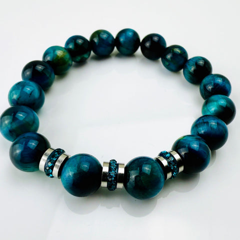 Blaugrünes Tigeraugen-Armband mit funkelnden Kristall-Edelstahl-Elementen, handgefertigt in der Schweiz. Vielseitiges und elegantes Design, das Strapazierfähigkeit und Stil vereint.
