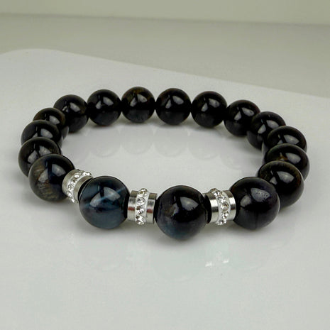 Schwarzes Tigeraugen-Armband mit funkelnden Edelstahl-Elementen und klaren Kristallen, handgefertigt in der Schweiz. Elegantes und modernes Design, perfekt für jeden Anlass.