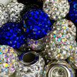 Glitzernde Tonstrassperlen mit kleinen Kristallen, die Licht reflektieren. Können im 'Style it yourself'-Konzept ausgewählt werden.