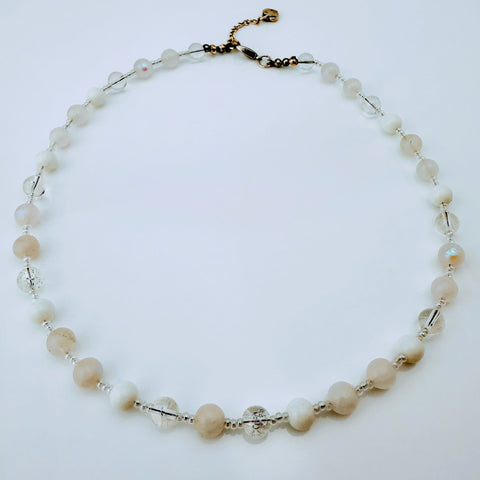Zierliche Damenhalskette aus Mondstein- und Achatperlen, kombiniert mit transparent-weißen Rocailles. Handgefertigtes Schmuckstück aus der Schweiz, ideal für minimalistische und elegante Outfits.